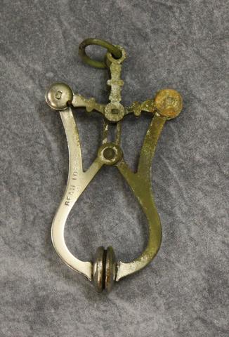 Skirt Lifter of silver metal constructed with movable parts