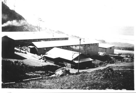 View looks southwest at Cape Creek Camp.  The three long buildings in the center of the photo were the bunkhouses