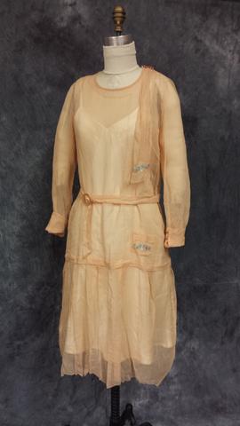 Dress of peach gauze with round neckline and long sleeves with cuffs