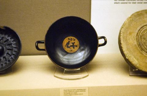 Potter attaches handle to kylix